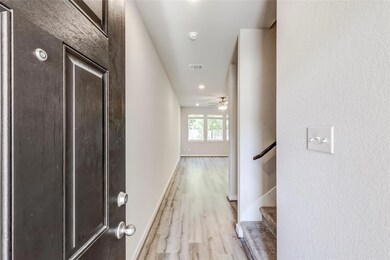 Hallway with light wood-style floors and baseboar