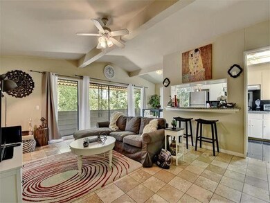 Living room featuring a ceiling fan and light til