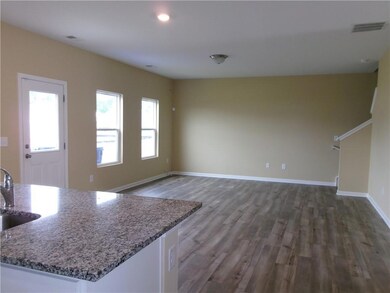 Unfurnished living room featuring wood finished fl
