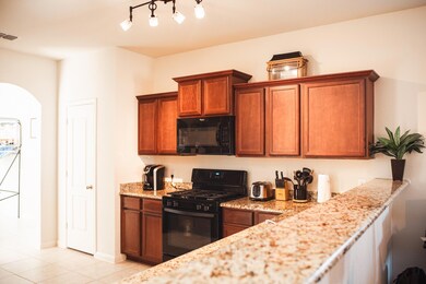 Kitchen featuring light stone countertops, light t