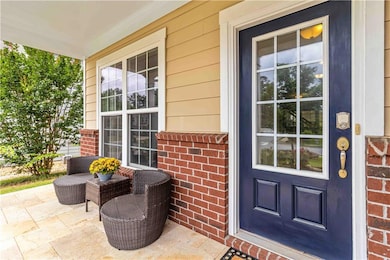 Entrance to property with covered porch and brick siding