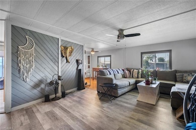 Living room featuring ceiling fan, a wealth of nat