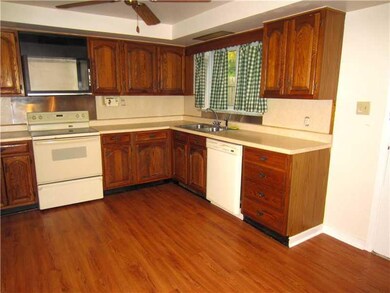 Kitchen. The Updated Eat-in Kitchen features Brand New Wood Laminate Flooring, Neutral Counter Tops, Ceiling Fan, and a Walk-Out to the Screened Porch, which can extend your Entertaining Space in the warmer months.