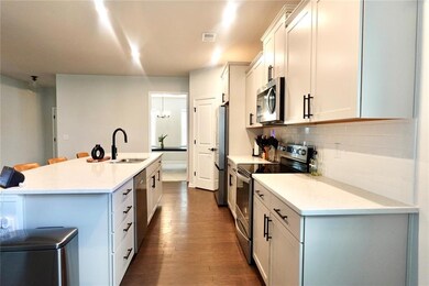 Kitchen with a sink, dark wood-style flooring, dec