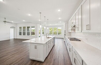Large island overlooking gathering room and dining areas