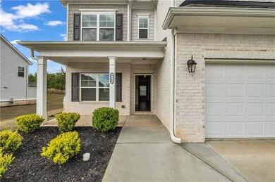 View of exterior entry with a porch, a garage, bri