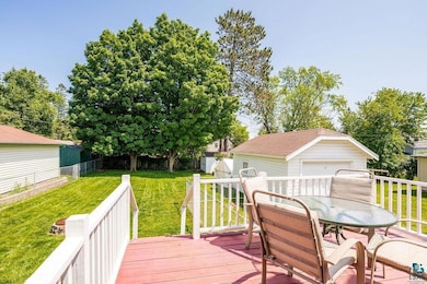 Deck with an outdoor structure, outdoor dining area, and a garage