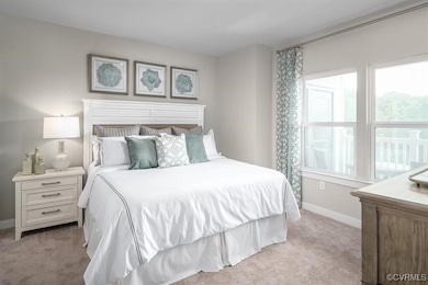 Bedroom featuring light carpet and baseboards