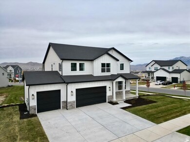 Modern farmhouse featuring a front yard, board and batten siding, concrete driveway, and a mountain view