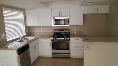 Kitchen with stainless steel appliances, a sink, w