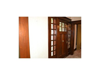 Walnut front door with beveled glass.