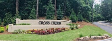 Community sign with a view of trees and a lawn