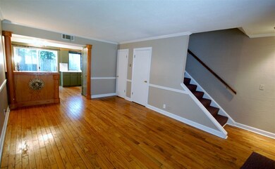 The living room features gorgeous hardwood floorin