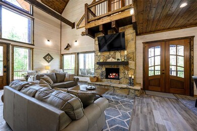 Living room with dark wood-type flooring, high vau
