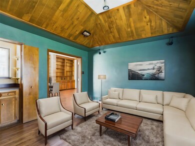 Den with vaulted ceiling, built in features, dark 
