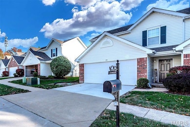 Traditional-style house featuring concrete driveway, brick siding, a residential view, and a garage