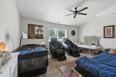Carpeted master bedroom with a ceiling fan and vaulted ceiling