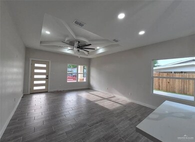 Spare room featuring a raised ceiling, wood tiled floors, a ceiling fan, and recessed lighting