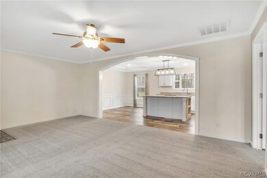 Unfurnished living room featuring ornamental moldi