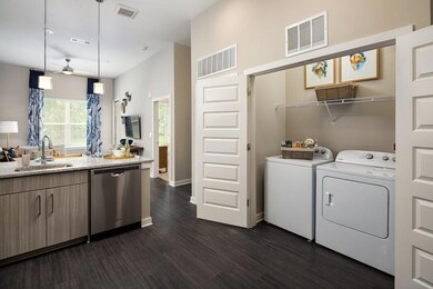 Washroom featuring washing machine and clothes dryer, dark wood-type flooring, and a ceiling fan