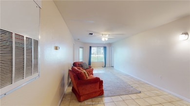 Sitting room featuring ceiling fan and light tile