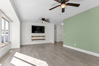 Unfurnished living room featuring light wood-style flooring and a ceiling fan