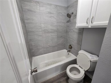 Full bathroom featuring wood finished floors, toi