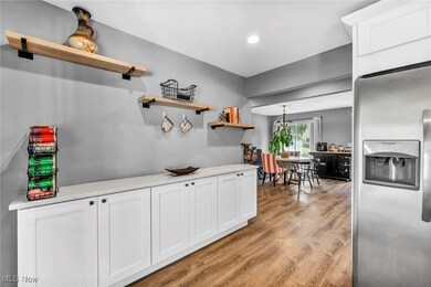 Kitchen with light wood-type flooring, white cabinets, and stainless steel appliances