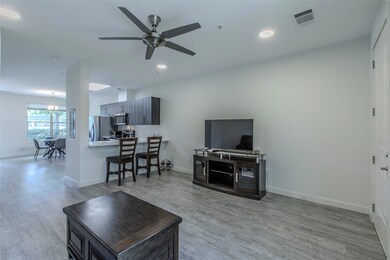 Living room featuring a ceiling fan, light wood f