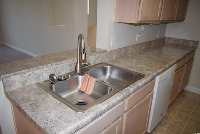 Kitchen with a sink, a peninsula, white dishwasher