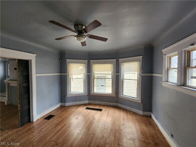 Unfurnished room featuring hardwood / wood-style floors, ceiling fan, and a healthy amount of sunlight