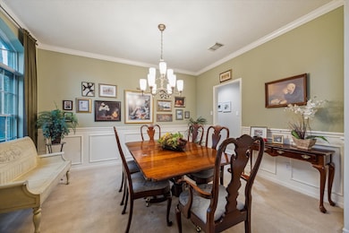 To the left of the entryway is a formal dining space complete with crown moulding and wainscoting wall accents.