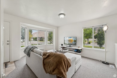 Living room with healthy amount of natural light and light carpet
