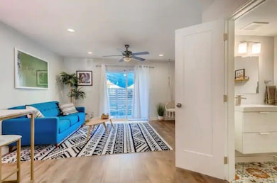 Living area with ceiling fan, wood finished floor