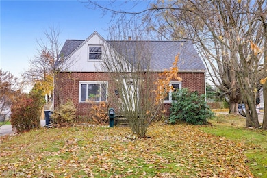 View of front facade featuring brick siding, a front yard, and a shingled roof