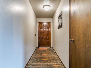 Entryway featuring brick flooring and baseboards