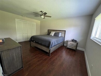 Spacious and serene, featuring rich wood-look flooring, neutral tones, ceiling fan, and large closet — a perfect retreat.