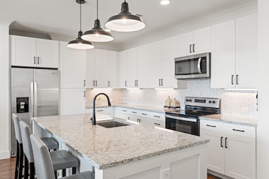 Kitchen featuring appliances with stainless steel finishes, tasteful backsplash, white cabinetry, pendant lighting, and recessed lighting