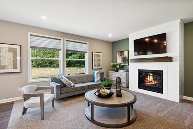Soaring windows provide an abundance of natural light to flow throughout the main level, including this nicely sized family room, featuring a natural gas fireplace. (Model photo)