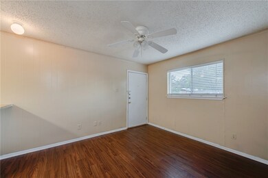 Empty room with wood finished floors, ceiling fan,