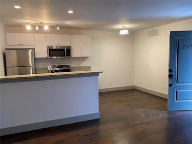 Kitchen with dark wood finished floors, appliances
