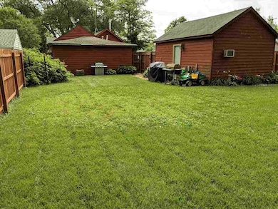 Fenced backyard facing home and garage.