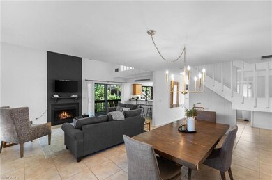 Tiled dining space featuring a fireplace and a notable chandelier