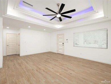 Unfurnished room featuring ceiling fan, visible vents, a raised ceiling, light wood finished floors, and recessed lighting