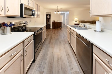 Kitchen with a chandelier, light brown cabinets, s