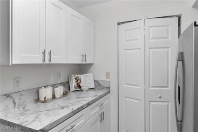 Kitchen featuring white cabinetry, stainless steel fridge with ice dispenser, and light countertops