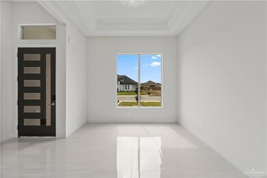Foyer entrance with crown molding, light tile patterned floors, and a tray ceiling
