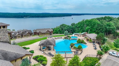 Community pool with a water view, a water slide, and a patio