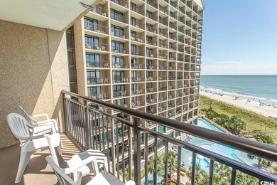 Balcony with view of water and beach and view of pool