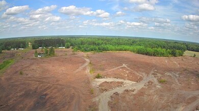 Aerial view of property and surrounding area with a forest